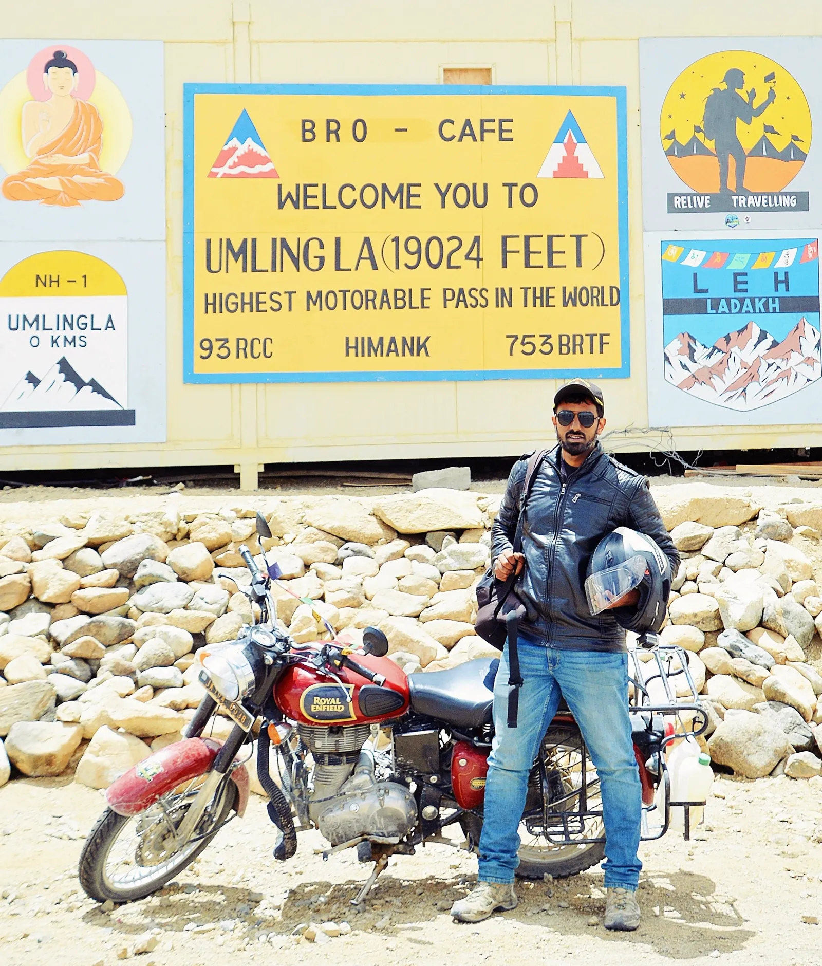 motociclista com Royal Enfield na placa do Umling La, passagem motorável mais alta do mundo